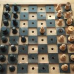 A Braille Chess board, all the black tiles are raised and each black piece has a raised dot on it's top.