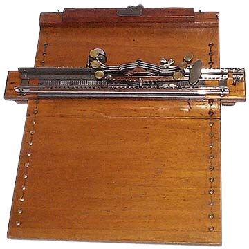 Stainsby braille, a small portable braille typewriter. It has a wooden board with the embosser slider horizontal. A page can be slid under and the braille can be typed on the 6 keys sticking out.